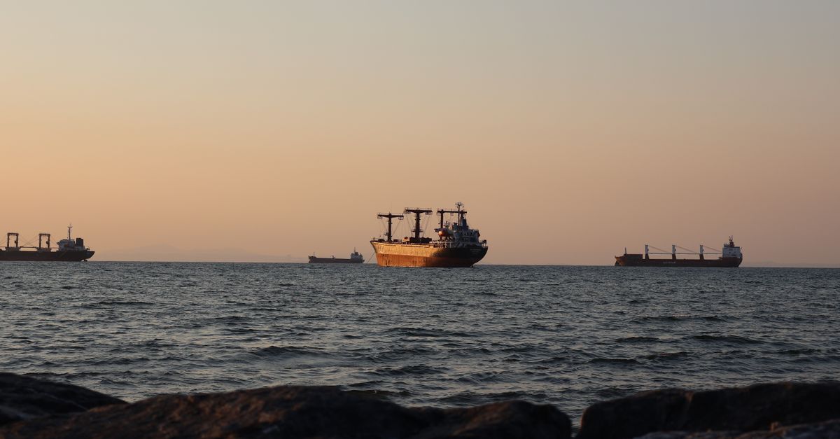Serene view of cargo ships sailing on İskenderun Bay at sunset, capturing the tranquil evening atmosphere.